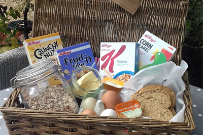 Brekfast hamper consisting of cereal, muesli, free range eggs, bread, butter, preserves, plus tea, coffee and hot chocolate